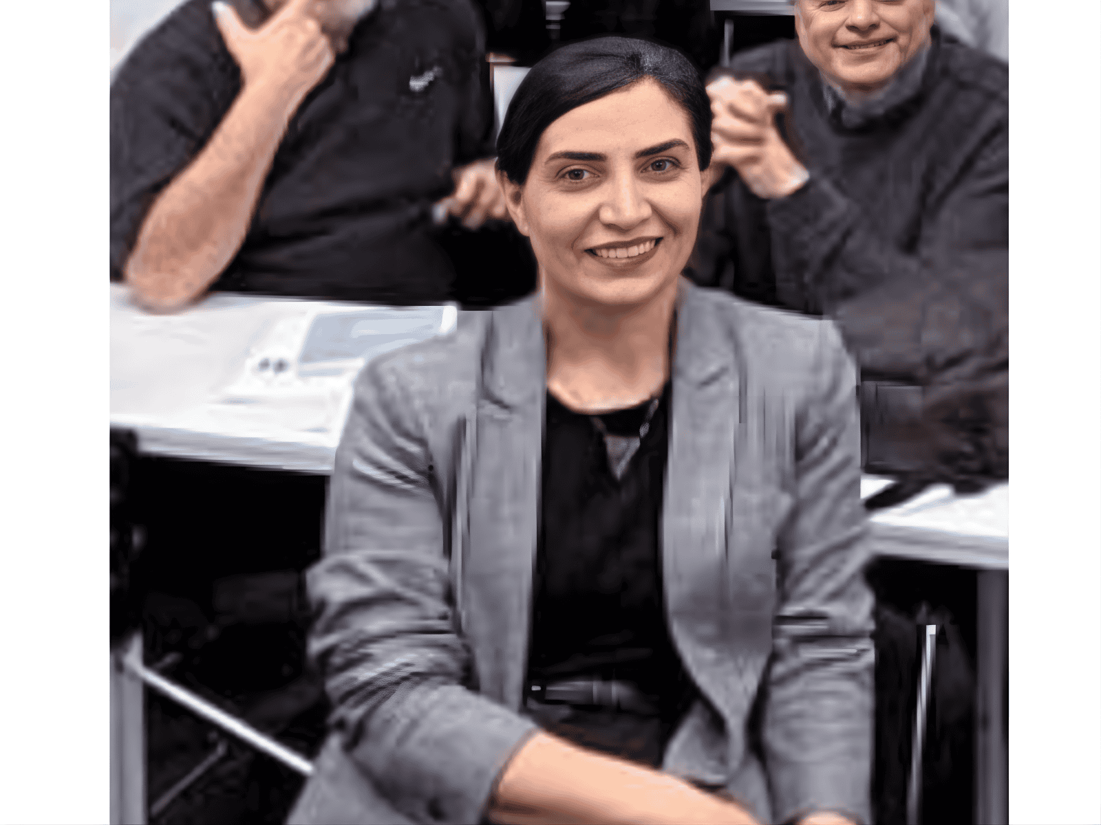 Empowered woman smiling at a professional business meeting, representing leadership and confidence.